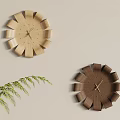 Flower Shaped Wooden Clocks in Light and Dark Wood on Light Wall with Green Fern Plant