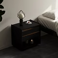 Black Nightstand With Drawers Geometric Lamp Small Plate And Candles By Bed With White Sheets