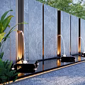 Gray Stone Feature Wall With Cascading Fountains Lush Green Plants Warm Lighting And Slate Pavement