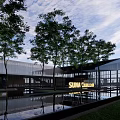 Modern Sales Office Building Featuring Glass Curtain Wall Water Pools Trees Pathway And Sky Reflections