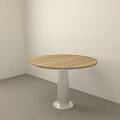 Round Dining Table with Wooden Top and Silver Metal Pedestal against Light Wall Gray Floor
