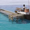 Vintage Wooden Steamship Docked at Pier with Cabin Over Blue Water
