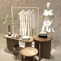 Clothing Store Featuring White Dresses Tops Mannequin Wooden Display Tables Green Plant And Shoes