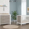 Cozy Nursery Room With White Crib Wooden Dresser Plant And Floral Wallpaper