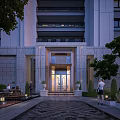 Elegant Building Entrance Gate With Illuminated Glass Door And Stone Facade Landscaped Surroundings