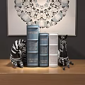 Decorative Books in Blue Silver with Zebra Figurines and Wall Art on Wooden Surface