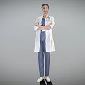 Female Doctor in White Coat and Blue Scrubs Standing with Crossed Arms on Gray Background