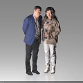 Two Middle Aged People Standing Together In Casual Coats Against Light Background