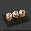 Freshly Baked Three Muffins Topped With White Powdered Sugar On Black Plate