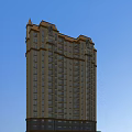 Tall Residential Building With Red Roof Yellow Walls Numerous Windows And Blue Sky Background