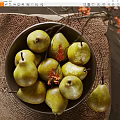 Ceramic Bowl Filled With Fresh Pears And Red Flowers On Woven Mat