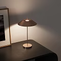 Minimalist Modern Table Lamp Illuminating Wooden Side Table With Framed Artwork And Small Coffee Mug