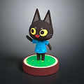 Black Cartoon Cat Figurine Wearing Blue Shirt Standing On Round Green Base With Red Edge