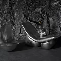 Sleek Metallic Leisure Chair With Modern Design Against Natural Rock Wall Background