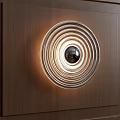 Modern Circular Wall Lamp With Layered Rings And Central Sphere On Wooden Panel