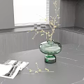 Green Glass Vase With Flower Branches On Black Marble Tabletop Near Magazine And Window