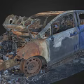 Burnt Car Wreckage With Rusted Body And Charred Interior Debris