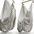 Cozy Light Gray Macramé Hanging Chair With Fringes And Patterned Pillows
