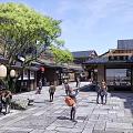Traditional Commercial Street With Stone Pavement Red Lanterns Trees And Pedestrians