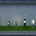 Various Designed Outdoor Lights With Geometric Patterns On Green Grass Against Gray Wall