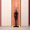 Black Human Figure Sculpture on Pedestal with Pink and White Wall Background and Hanging Light