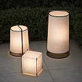 Modern Outdoor Floor Lamps With Various Shapes Fabric Shades And Metal Frames On Stone Patio