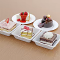 Assorted Delicious Cakes with Strawberry Cream and Chocolate on White Plates and Square Containers