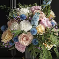 Colorful Mixed Flowers Arrangement In Black Vase With Gold Base And Green Leaves Ferns