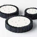 Three Circular Decorative Objects With Textured Black Edges And White Centers 3d model