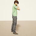 Man Standing in Green Polo Shirt Gray Pants and Gray Shoes Touching Ear with One Hand