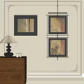 Abstract Paintings With Black Frames Hanging On Wall Near Wooden Cabinet With Lamp And Bottles