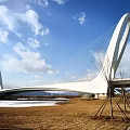 Modern White Arch Bridge With Cable Stay Design Over River And Blue Sky
