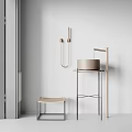 Modern Round Washbasin with Metal Stand and Woven Stool against White Wall in Minimalist Design
