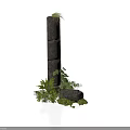 Modern Stone Pillar Display With Stacked Dark Stones And Surrounding Green Plants