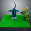 Black Windmill Model Display On Green Grass Base With Small Tree