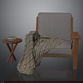 Gray Cushioned Chair With Wooden Armrests Plaid Blanket And Cross Legged Side Table With Books