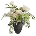 Floral Arrangement in Black Vase With White Roses Green Leaves And Small Flowers
