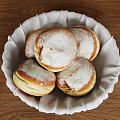 Fresh Round Powdered Sugar Pastries In White Cloth Lined Basket On Wooden Table