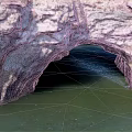 Scenic Natural Rock Arch Formation Over Calm Green Coastal Water