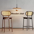 Wooden Bar Stools with Wicker Backrest Brown and Black Against Gray Wall with Pendant Light