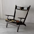 Wooden Frame Lounge Chair With Woven Backrest And Patterned Cushion Near Green Plant
