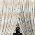 Elegant Beige Curtains With Flowing Drapery And Black Decorative Vase