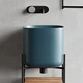 Cylindrical Blue Washbasin on Black Metal Stand with Grey Wall Background