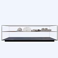 Shopping Mall Counter Featuring Glass Display Case With White Shirts Hats And Folded Merchandise