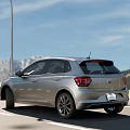 Silver Volkswagen Hatchback Parked Outdoor Near Scenic Buildings And Greenery View