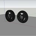 Two Black Circular Stove Components Against White Wall And Blue Sky