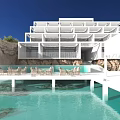 Modern Detached Villa Exterior With Swimming Pool Palm Trees And Lounge Chairs Under Blue Sky