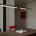 Modern Linear Pendant Light Hanging Over Wooden Table With Red Black Chairs And Wall Art