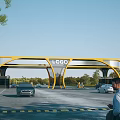 Modern Yellow Curved Entrance Gate With Logo Sign And Cars Passing By