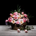 Pink and Beige Flower Arrangement in Wicker Basket with Green Leaves on Wooden Table